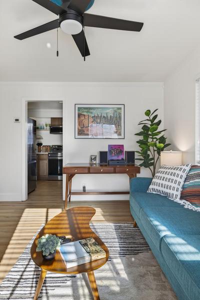 View over the coffee table and sofa to the desk and the open kitchen doorway
