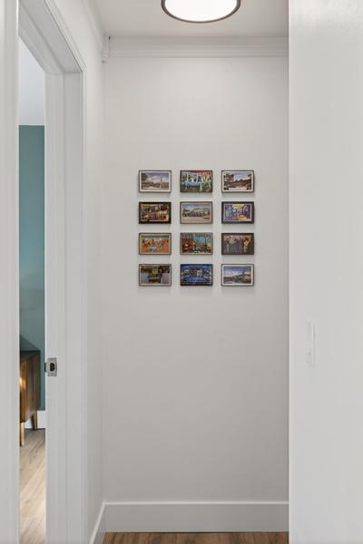 Hallway to the bedroom, hung with a grid of framed vintage Reno postcards