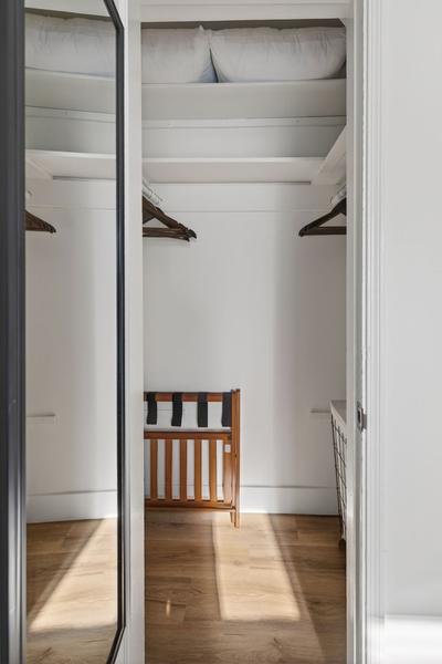Closet with a mirrored sliding door, a hanging rail, spare pillows on the shelf and a folding luggage rack