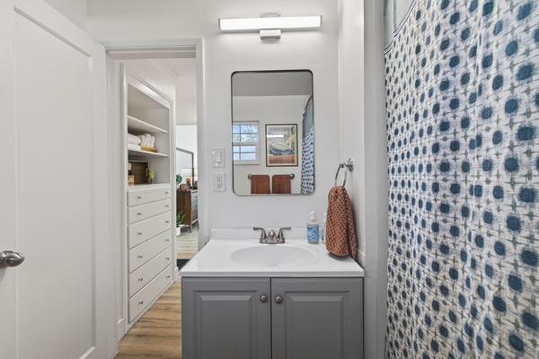 Bathroom vanity with a mirror, light bar and cabinet, seen from the doorway