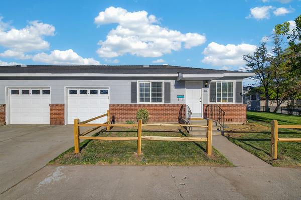 The two attached garages side by side in the middle of the duplex, with the driveway in front